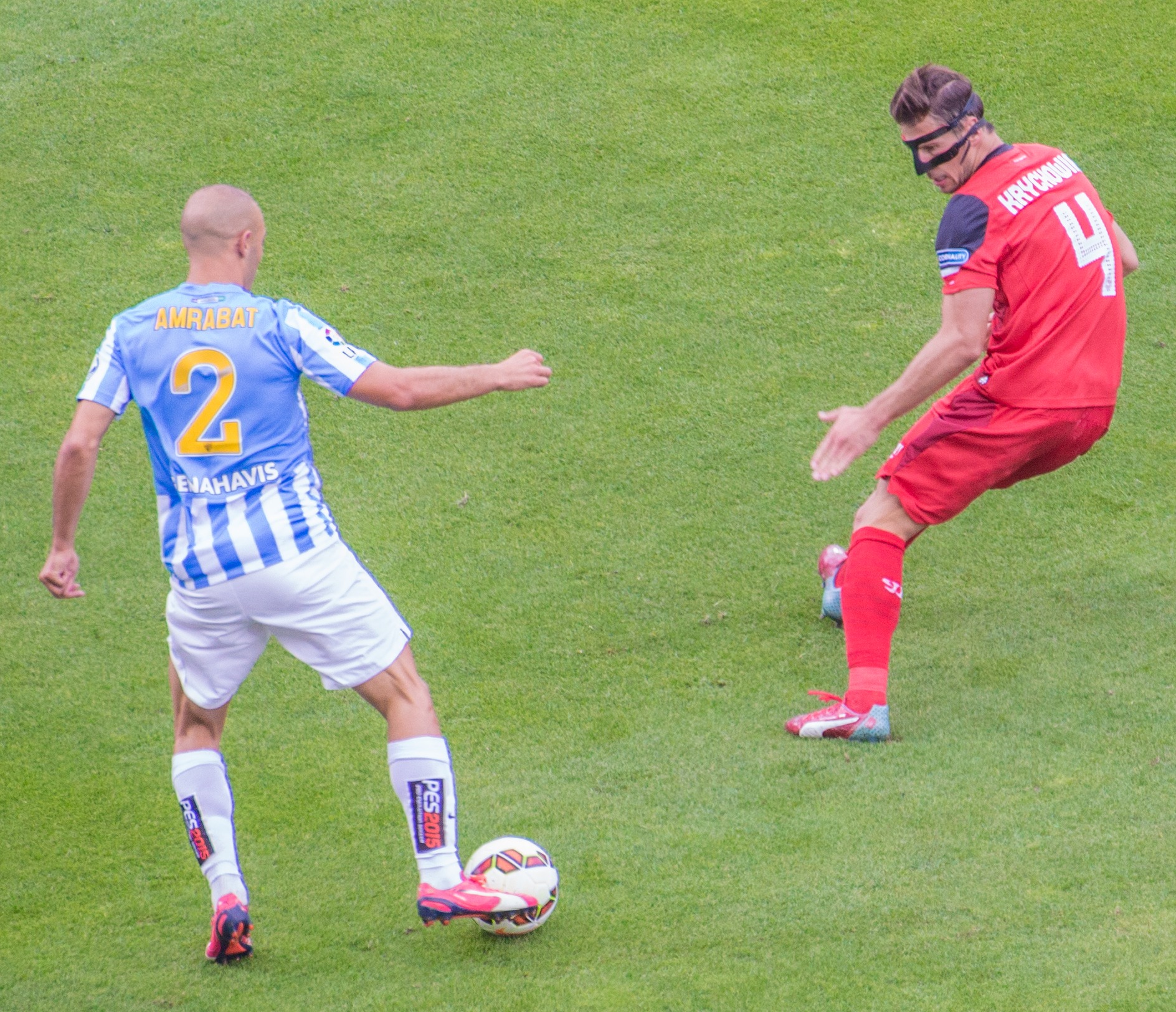 Grzegorz Krychowiak w czerwonej koszulce z numerem 4 i maską na twarzy podczas meczu.