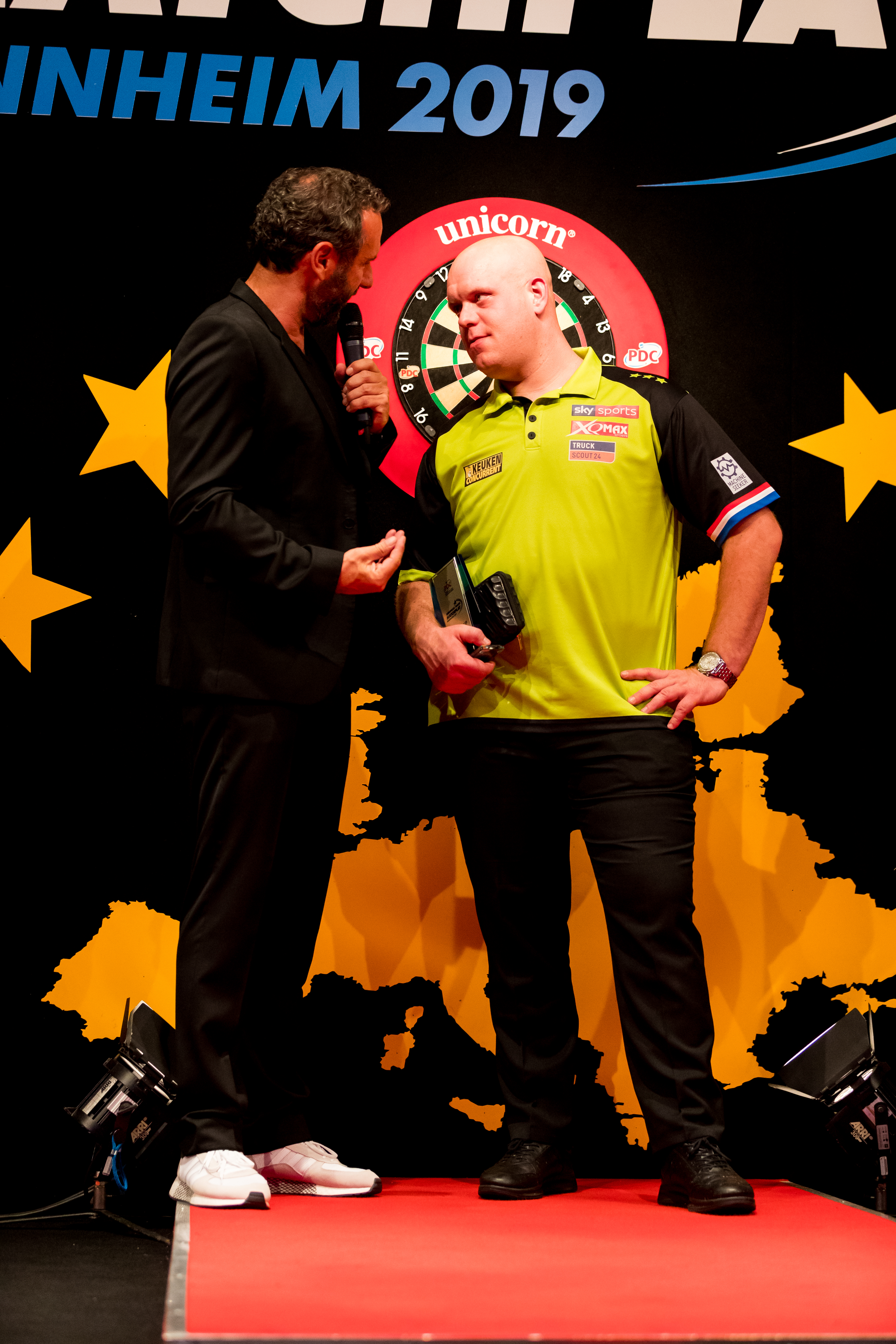 Michael van Gerwen podczas wywiadu po meczu darta, trzymając trofeum.