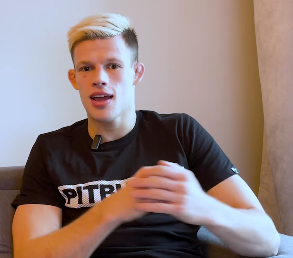 Jakub Wikłacz, polski wojownik UFC, w czarnej koszulce Pitbull, z blond fryzurą.