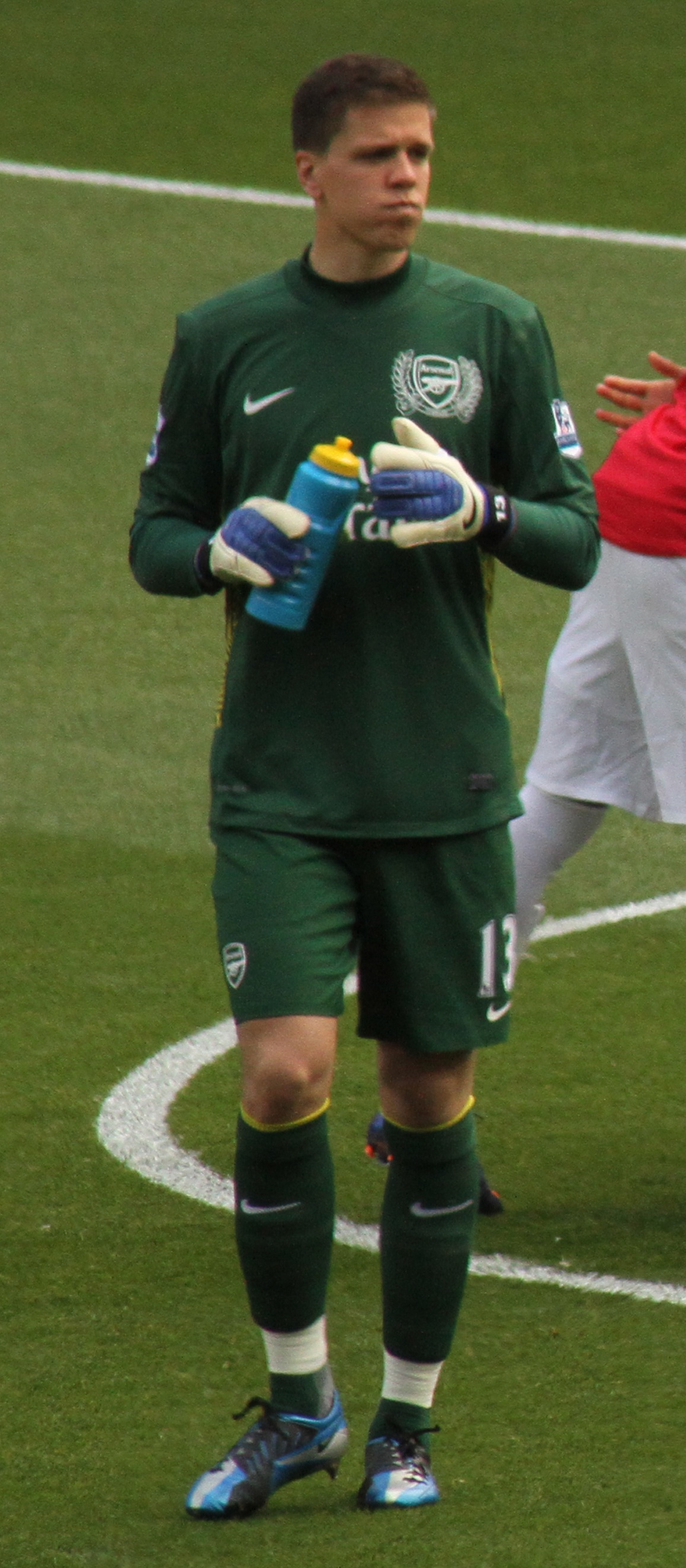 Wojciech Szczęsny, bramkarz, w zielonym stroju z niebieską butelką w ręce.