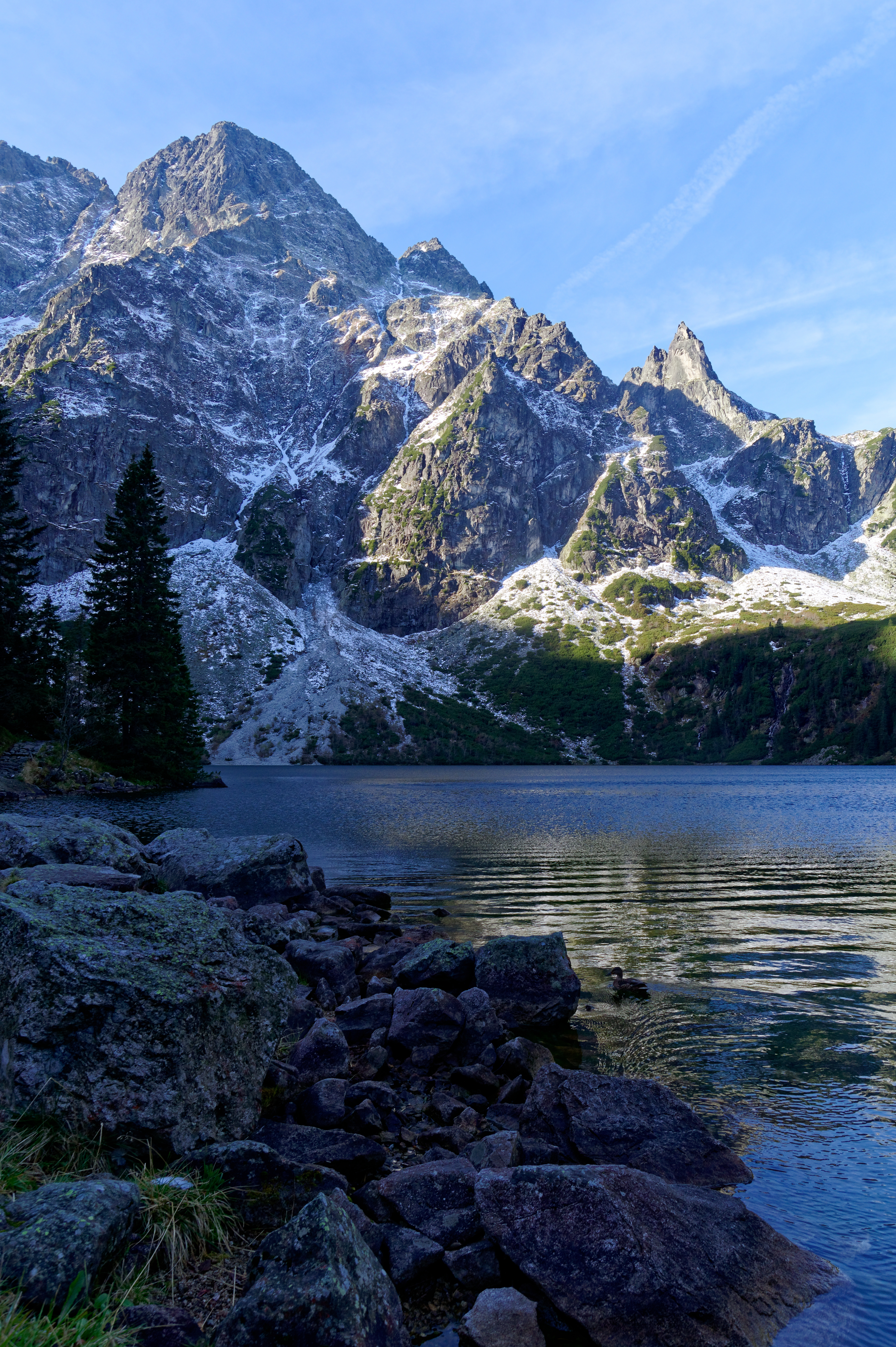 Majestatyczne Morskie Oko z ośnieżonymi szczytami Tatr w tle, idealne na malowniczą wycieczkę.