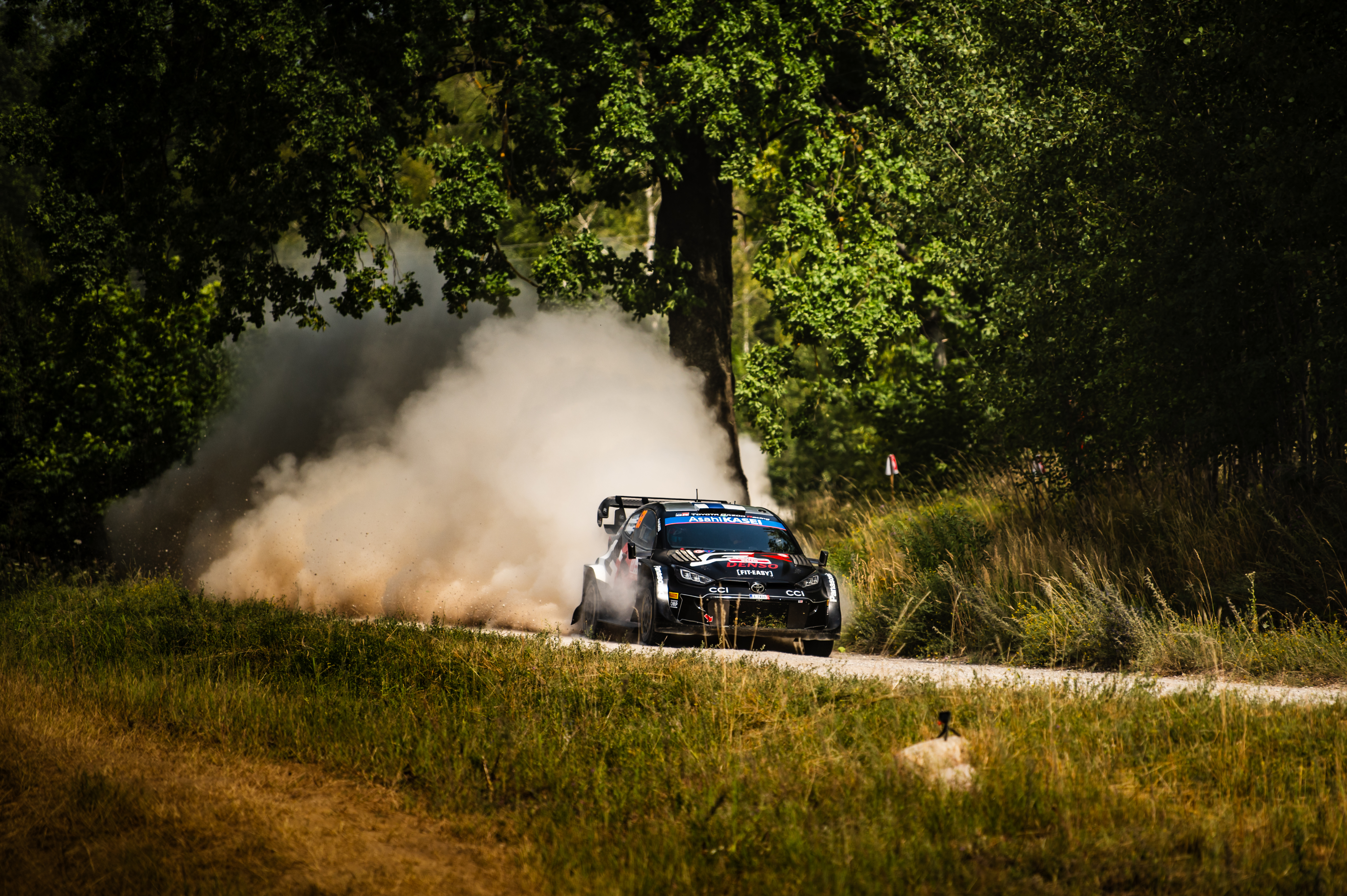 Kalle Rovanperä w rajdowym samochodzie Toyota Yaris WRC na szutrowej trasze, unosząc tumany kurzu.