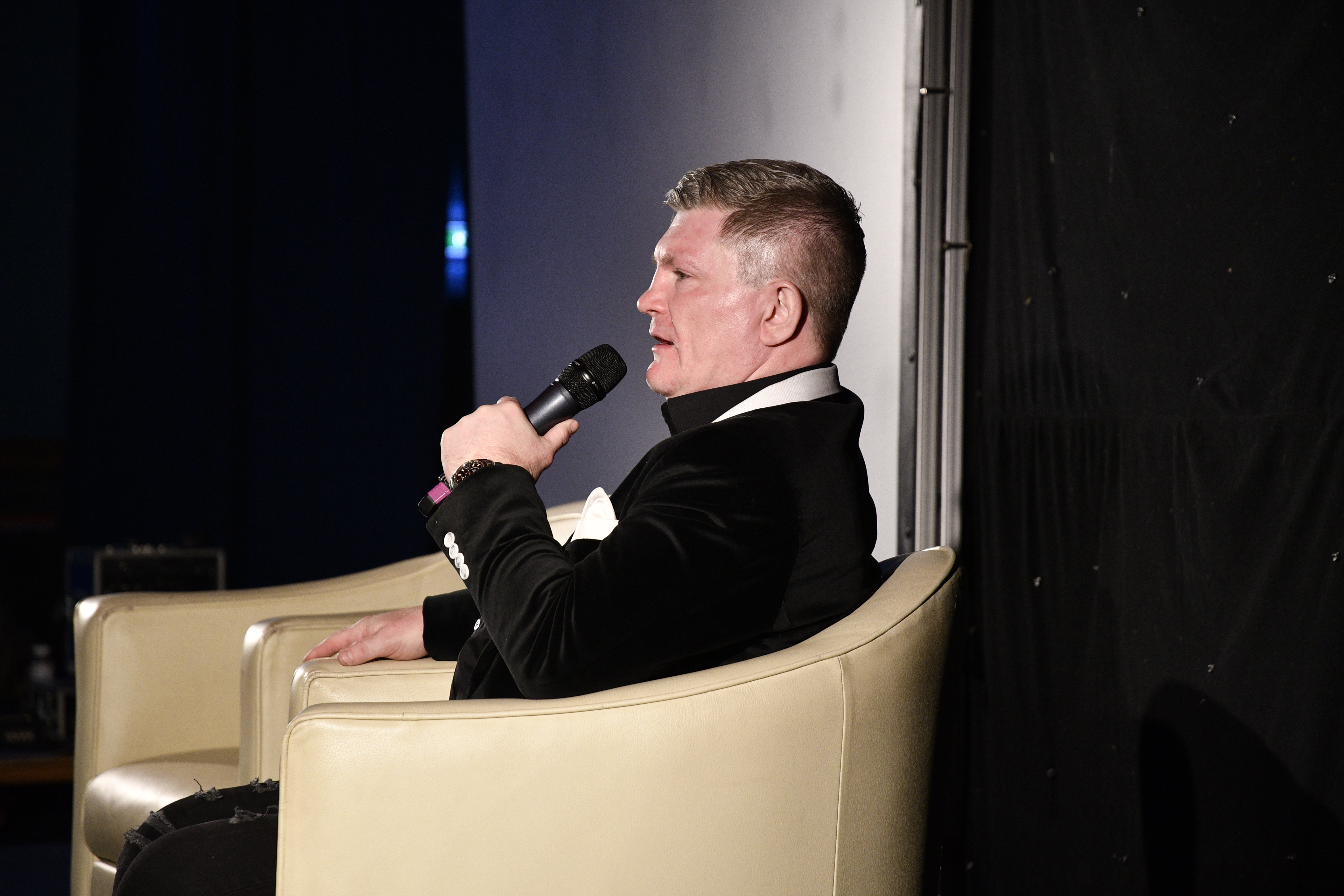 Ricky Hatton podczas pogrzebu legendy boksu, siedzący i trzymający mikrofon.