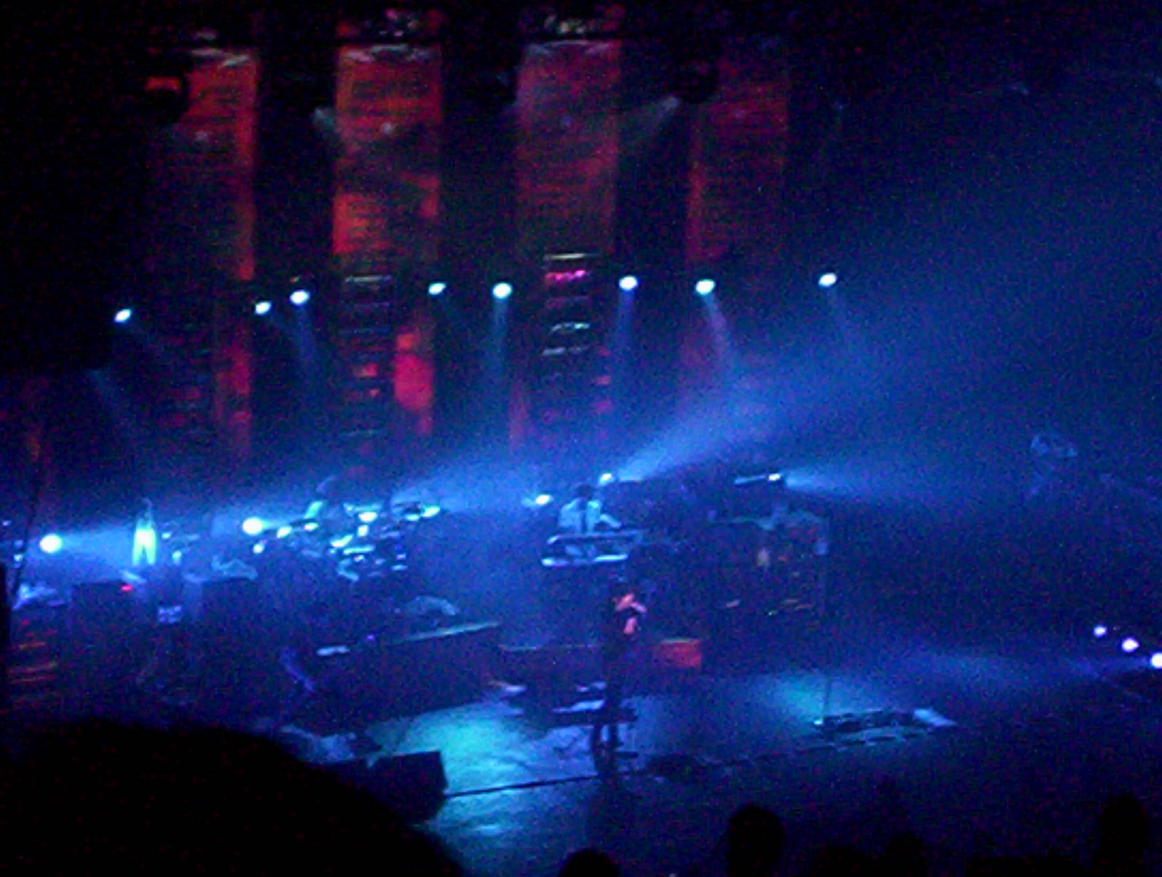 Koncert zespołu Lostprophets z Ianem Watkinsem na scenie, w niebieskich i czerwonych światłach.