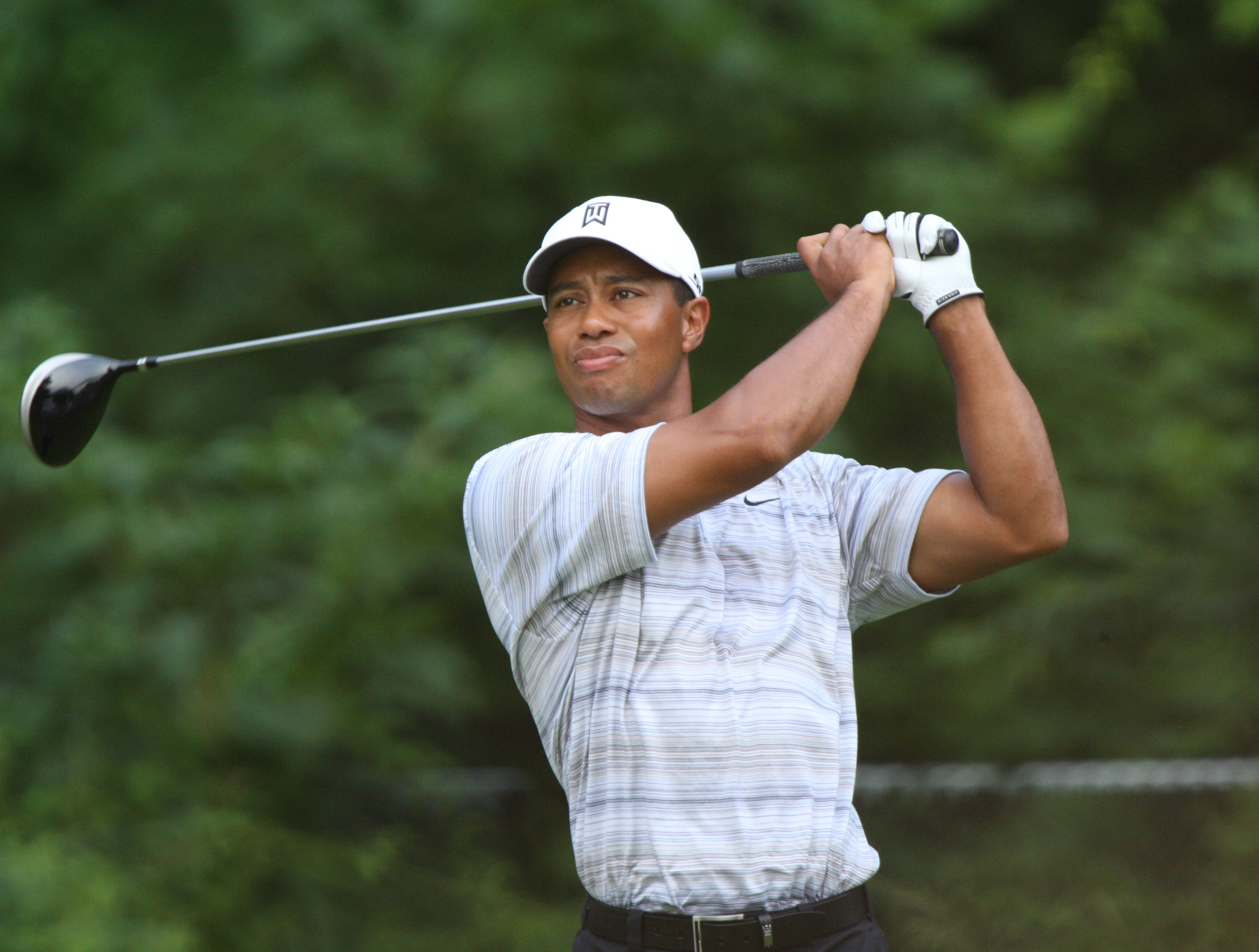 Tiger Woods podczas uderzenia kijem golfowym, symbolizujący jego karierę i walkę z kontuzjami.