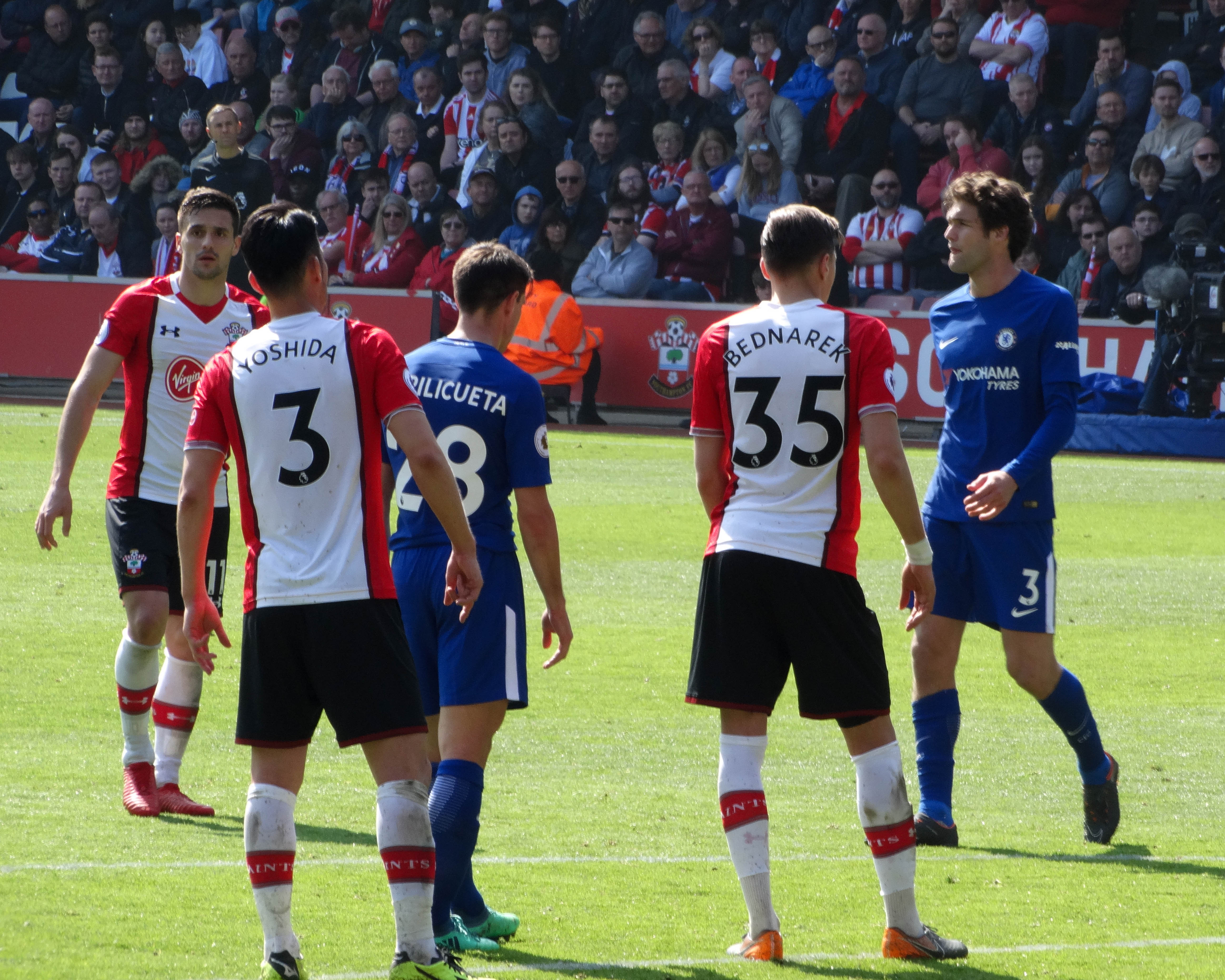 Jan Bednarek w koszulce z numerem 35, piłkarz omawiający taktykę gry.