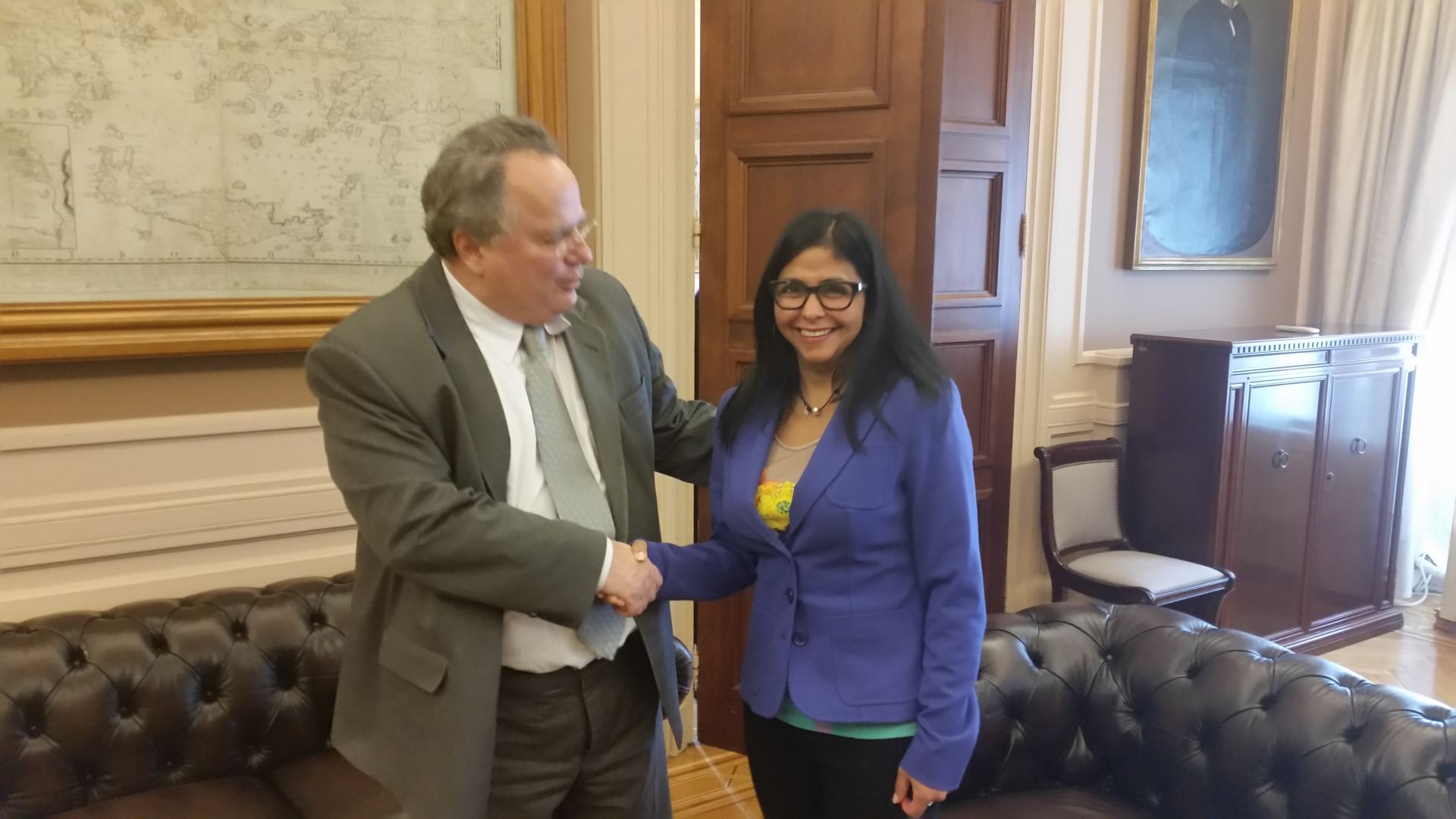 Delcy Rodriguez, nowa prezydentka Wenezueli, ściska dłoń urzędnika państwowego.